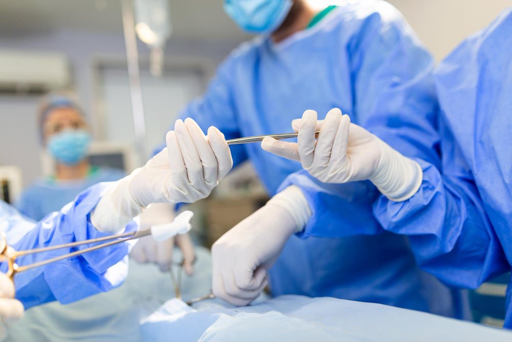 A group of surgeons performing private hip replacement surgery on a patient.